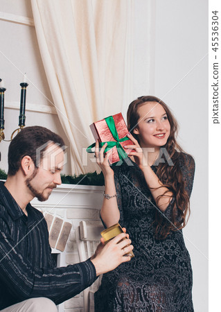 tguy decorates tree, girl sitting with a gift tguy decorates tree, girl sitting with a gift 45536304