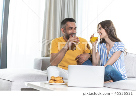 Laughing husband and wife are drinking orange juice Laughing husband and wife are drinking orange juice 45536551