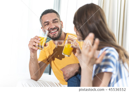 Happy couple is laughing and drinking orange juice 45536552
