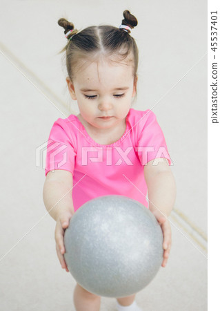 a little girl in a pink swimsuit doing gymnastics a little girl in a pink swimsuit doing gymnastics 45537401
