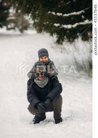 Happy father with his son walks through the park in the snowy winter weather 45537646
