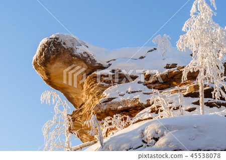 snow-covered rock against a blue sky 45538078