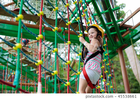 Child in adventure park. Kids climbing rope trail. 45538661