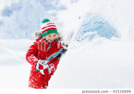 Child brushing off car. Kid with winter snow brush Child brushing off car. Kid with winter snow brush 45538899