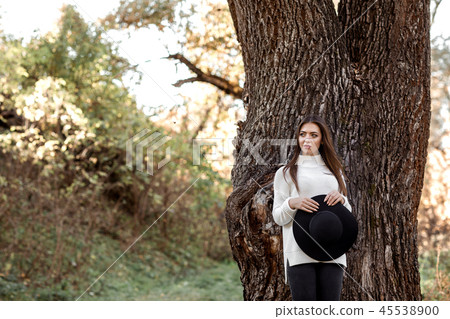 beautiful woman in hat standing near big tree beautiful woman in hat standing near big tree 45538900
