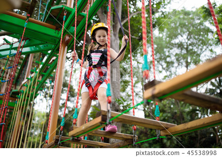 Child in adventure park. Kids climbing rope trail. 45538998