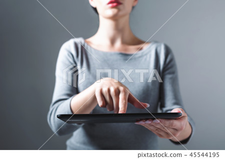 Young woman using her tablet Young woman using her tablet 45544195