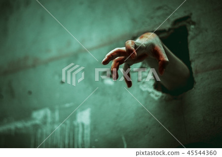 Zombie hand through the cracked wall 45544360