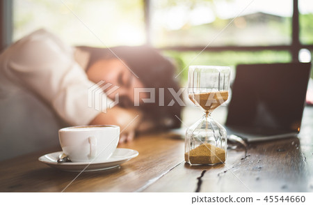 Close up of sandglass with business woman tired from working wit 45544660