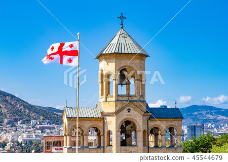 Beautiful view to Georgian Flag on the background chapel on site to Sameba Cathedral Tsminda in 45544679