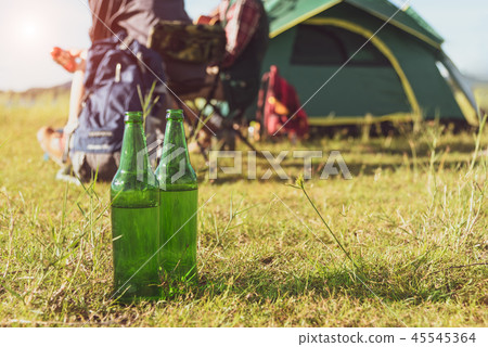 Close up of beer bottle in meadow while camping 45545364