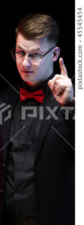 Portrait of confident handsome elegant responsible businessman with idea gesture on black background 45545454