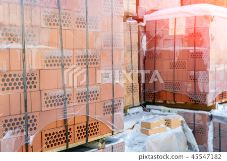 Stock pallets of red bricks wrapped in stretch film at wholesale outdoor market ot store 45547182