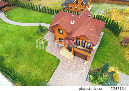 Beautiful luxury big wooden house. Timber cottage villa with with green lawn, garden and blue sky on 45547184