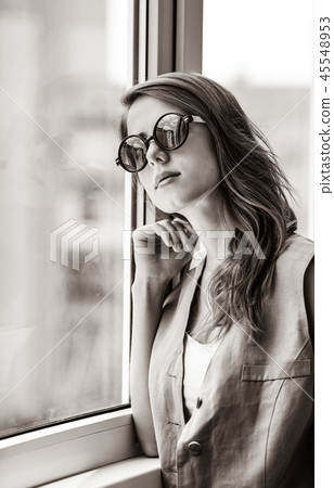 Grunge girl in sunglasses near window Grunge girl in sunglasses near window 45548953