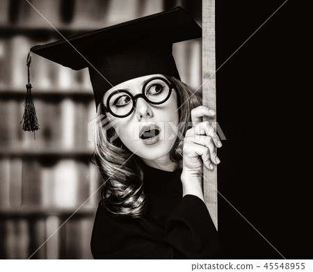 graduating student girl in an academic gown near blackboard graduating student girl in an academic gown near blackboard 45548955