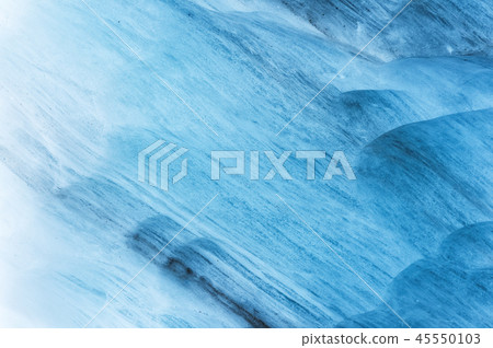 Close-up wall of a centuries-old glacier with a structure of stripes and bubbles. Ice blue light Close-up wall of a centuries-old glacier with a structure of stripes and bubbles. Ice blue light 45550103