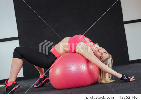 Slender woman in sportswear, doing exercises with the ball Slender woman in sportswear, doing exercises with the ball 45552446