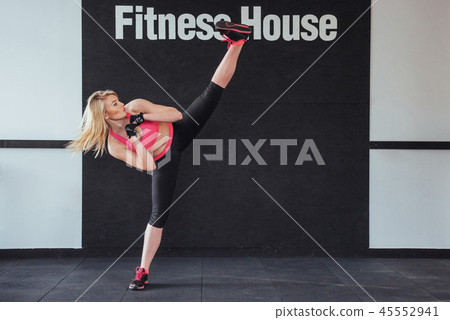 boxer woman giving kick in the gym on black white background 45552941