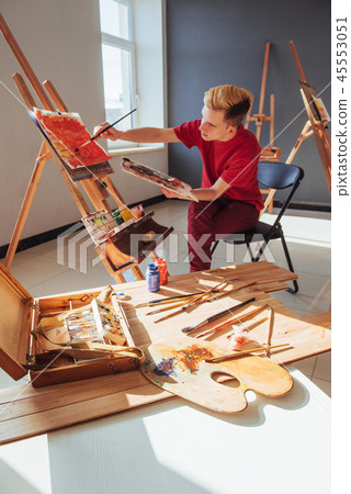 young artist paints a picture in the studio 45553051