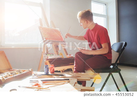 young artist paints a picture in the studio 45553052