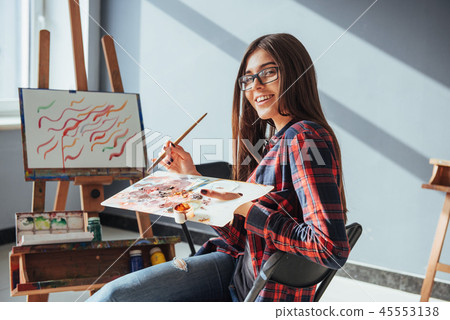 Pretty Pretty Girl artist paints on canvas painting on the easel. 45553138