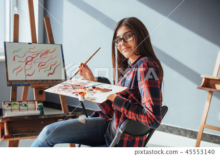 Pretty Pretty Girl artist paints on canvas painting on the easel. 45553140
