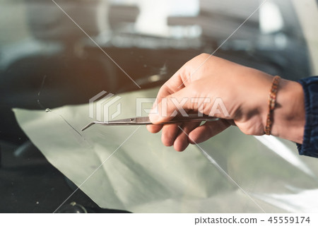 Close up Automobile glazier worker fixing and repair windscreen or windshield of a car in auto 45559174