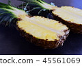 Halves of pineapple on black concrete background. 45561069