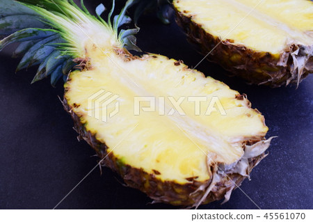 Halves of pineapple on black concrete background. Halves of pineapple on black concrete background. 45561070