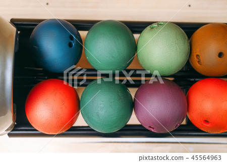 Rows of color bowling balls in feeder, top view 45564963