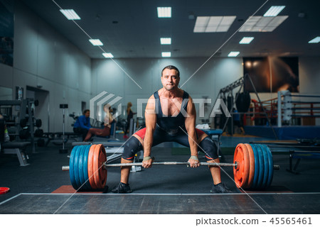 Male weightlifter prepares to pull heavy barbell Male weightlifter prepares to pull heavy barbell 45565461