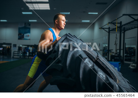 Athlete doing exercise with truck tyre, crossfit Athlete doing exercise with truck tyre, crossfit 45565464