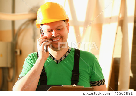 Carpenter talking on phone in hardware store Carpenter talking on phone in hardware store 45565981
