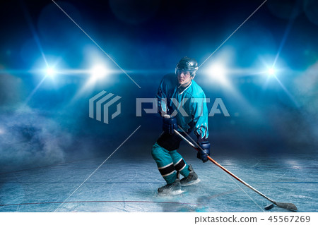 One hockey player on ice, spotlights on background 45567269