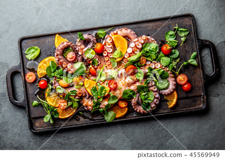 Whole octopus salad with orange, tomatoes and cress salad served on board with wine 45569949