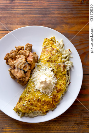 VENEZUELAN FOOD. Corn CACHAPA with cheese and fried pork - cochino frito. Wooden background, top 45570030
