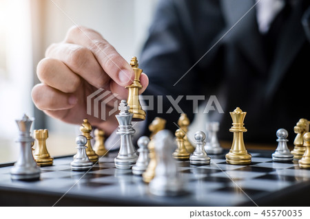 Hands of confident businessman playing chess game to development Hands of confident businessman playing chess game to development 45570035