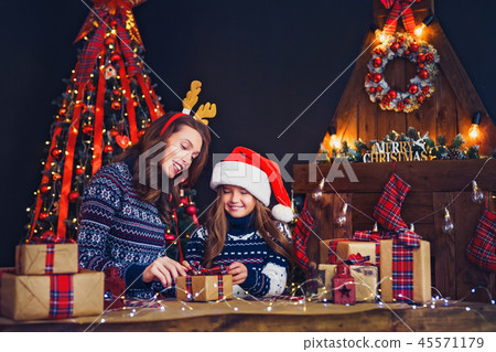 a happy family mother and child pack Christmas gifts 45571179