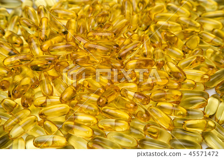 Background of yellow fish oil in capsules 45571472