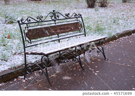 The bench in the park is covered with the first snow The bench in the park is covered with the first snow 45571699