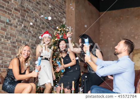 Young happy people having fun at Ney Year's party with confetti 45572784