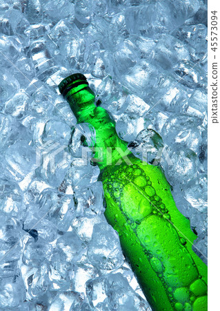 Bottle of beer in ice cubes.Closeup.Green bottle. Bottle of beer in ice cubes.Closeup.Green bottle. 45573094