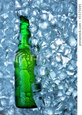 Bottle of beer in ice cubes.Closeup.Green bottle. Bottle of beer in ice cubes.Closeup.Green bottle. 45573095