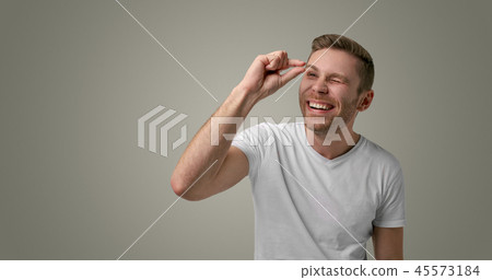 Jolly young man has bristles, giggles at camera Jolly young man has bristles, giggles at camera 45573184