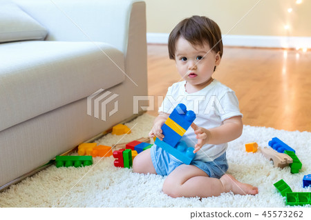 Toddler boy playing with his toys Toddler boy playing with his toys 45573262