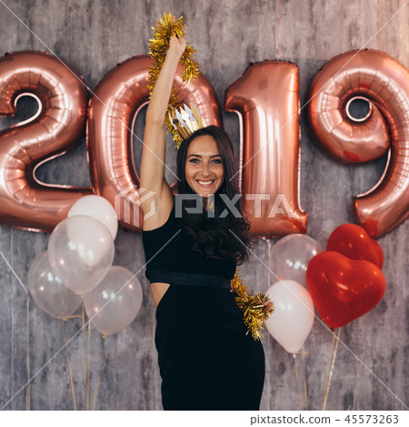 Woman holding balloons looking at camera. Celebration holiday new year 45573263