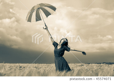 girl is standing on a wheat field with umbrella girl is standing on a wheat field with umbrella 45574071