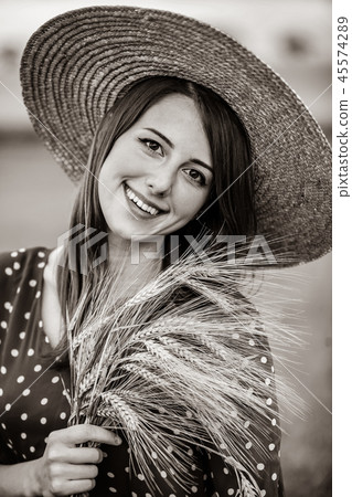 farm girl holding wheat ears on a field 45574289