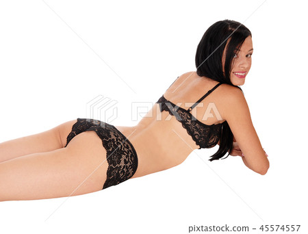 Woman lying in lingerie on her stomach smiling Stock Photo